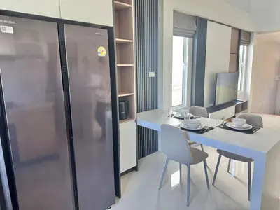 a room with a table and chairs and a refrigerator at Modern townhome in Phuket in Ban Phak Chit