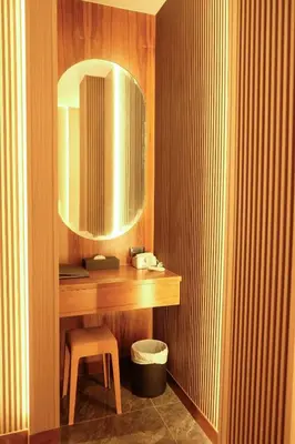 a bathroom with a vanity with a stool and a mirror at Private Jacuzzi Pool Suite near walking street in Patong Beach