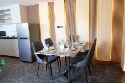a dining room with a table with chairs and a refrigerator at Private Jacuzzi Pool Suite near walking street in Patong Beach