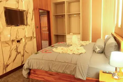 a bedroom with a bed with a tv on the wall at Private Jacuzzi Pool Suite near walking street in Patong Beach