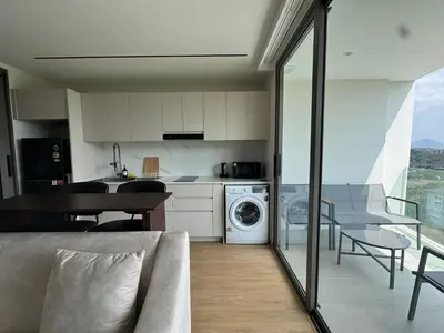 a kitchen with a washer and dryer in a room at Modern 1BR Condo Top Floor Pool, Cinema & Fast WiFi Next to Boat Avenue in Phuket