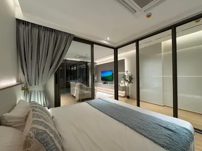 a bedroom with a large bed and large windows at Modern 1BR Condo Top Floor Pool, Cinema & Fast WiFi Next to Boat Avenue in Phuket