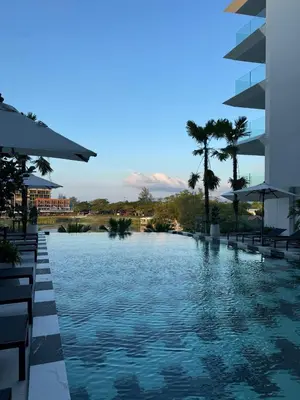 a pool at a resort with palm trees and water at Modern 1BR Condo Top Floor Pool, Cinema & Fast WiFi Next to Boat Avenue in Phuket