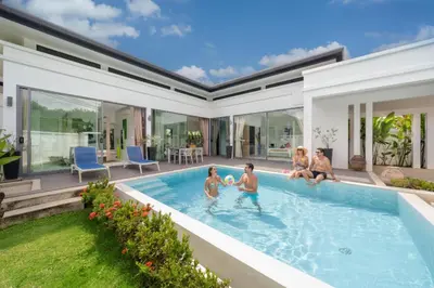 a family playing in the swimming pool of a house at 2 BR Pool Villa Isawan near Nai Harn in Ban Saiyuan (1)