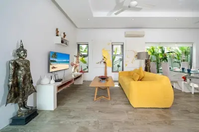 a living room with a yellow couch and a table at 2 BR Pool Villa Isawan near Nai Harn in Ban Saiyuan (1)