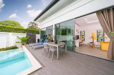 an outdoor patio with a table and chairs and a pool at 2 BR Pool Villa Isawan near Nai Harn in Ban Saiyuan (1)
