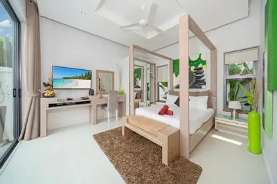a bedroom with a bed and a desk with a television at 2 BR Pool Villa Isawan near Nai Harn in Ban Saiyuan (1)