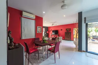 a dining room with red walls and a table and chairs at 3 BR Pool Villa Salika near Rawai Beach in Ban Saiyuan (1)
