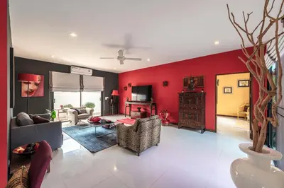 a living room with a red wall at 3 BR Pool Villa Salika near Rawai Beach in Ban Saiyuan (1)