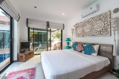 a bedroom with a large bed and a tv at 3 BR Pool Villa Salika near Rawai Beach in Ban Saiyuan (1)