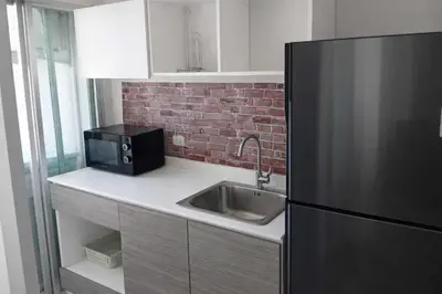 a kitchen with a sink and a black refrigerator at D Condo Mine Kathu Smart Monthly Living 30-Day Stay in Kathu