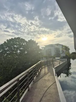 a bridge over a body of water with a building at The Ark Condomisunset in Ban Karon