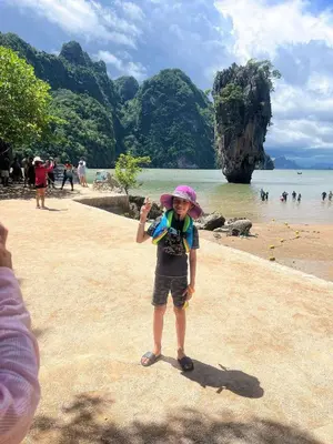 a young child standing on a beach at The Ark Condomisunset in Ban Karon