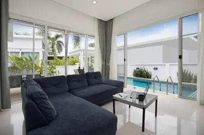 a living room with a blue couch and a table at Green 9 Private Pool Villa 2BR near Rawai Beach in Ban Saiyuan (1)