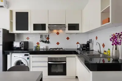 a kitchen with white cabinets and a sink at Green 9 Private Pool Villa 2BR near Rawai Beach in Ban Saiyuan (1)