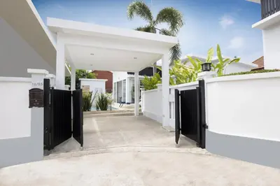 an entrance to a white house with black gates at Green 9 Private Pool Villa 2BR near Rawai Beach in Ban Saiyuan (1)