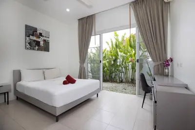 a bedroom with a bed and a desk and a window at Green 9 Private Pool Villa 2BR near Rawai Beach in Ban Saiyuan (1)