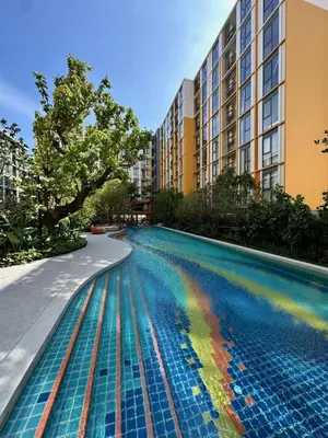 a pool with a rainbow in the water next to a building at Rest&Rise Phuket in Ban Rangeng