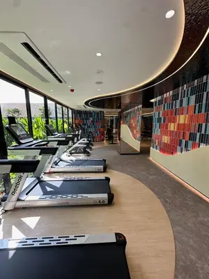 a row of treadmills in a room with windows at Rest&Rise Phuket in Ban Rangeng