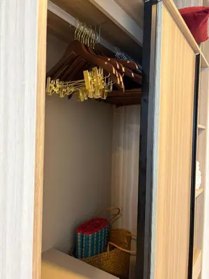 a closet with a wooden door and a basket at Rest&Rise Phuket in Ban Rangeng