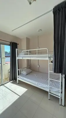two bunk beds in a room with a balcony at rawai cozy hostel in Rawai Beach