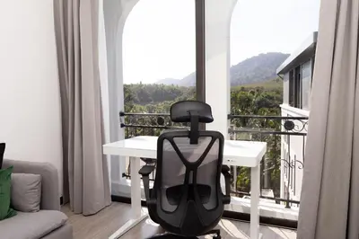 a chair sitting in front of a balcony with a view at Harmony Condominium Phuket in Ban Saiyuan (1)