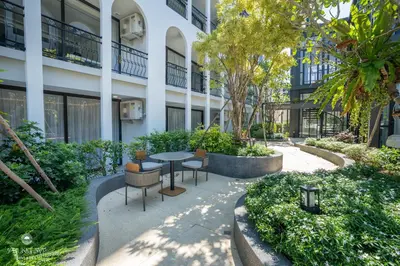 a courtyard with a table and chairs in front of a building at Harmony Condominium Phuket in Ban Saiyuan (1)