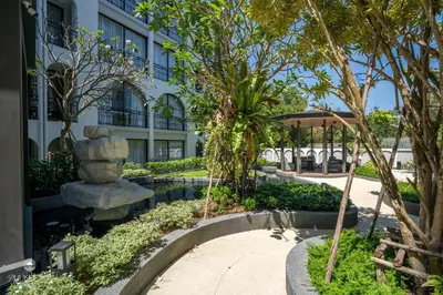 a park in front of a building with a statue at Harmony Condominium Phuket in Ban Saiyuan (1)