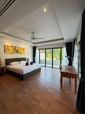 a bedroom with a bed and a table and windows at Harmony 3 Bedrooms Private Pool Villa in Laguna Phuket
