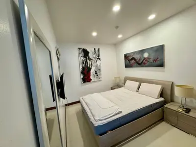 a small bedroom with a bed and paintings on the wall at One BR 24 in Ban Karon