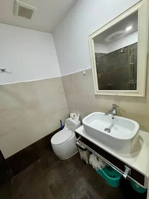 a bathroom with a sink and a toilet and a mirror at One BR 24 in Ban Karon