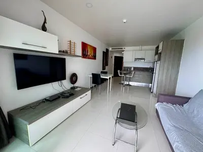 a living room with a large television and a couch at One BR 24 in Ban Karon