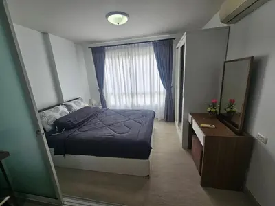a bedroom with a bed and a dresser and a window at Dcondo in Ban Kathu