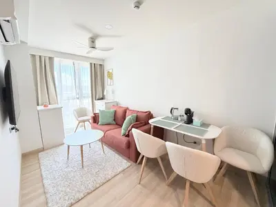 a living room with a red couch and a table at Skypark 4th floor Mountain View terrace in Laguna Phuket