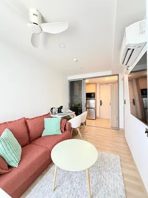 a living room with a red couch and a table at Skypark 4th floor Mountain View terrace in Laguna Phuket
