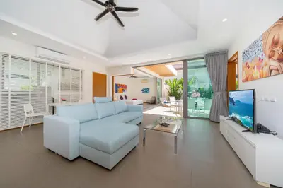 a living room with a white couch and a tv at 2BR Pool Villa Kate - KA Villas near Rawai Beach in Rawai Beach