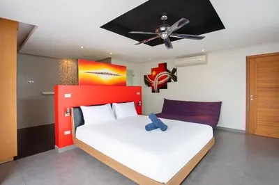 a bedroom with a bed with a ceiling fan at 3 BR Pool Villa Kloua near Chalong Temple in Ban Na Bon