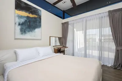 a bedroom with a white bed and a window at Townhouse Laguna Park 3 bedrooms in Laguna Phuket
