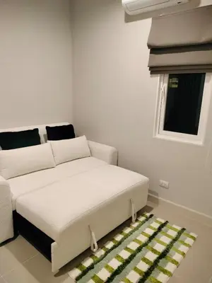 a white couch in a room with a window at Phuket Paklok Cozy Home in Ban Pa Khlok