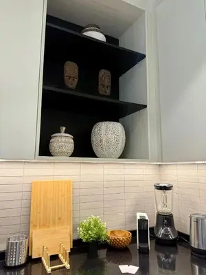 a kitchen with a counter with vases on shelves at Bali Essence, The Title BangTao in Bang Tao Beach