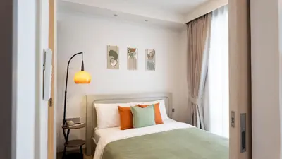 a bedroom with a bed with orange and green pillows at Natural Harmony - SkyPark Celeste in Laguna Phuket