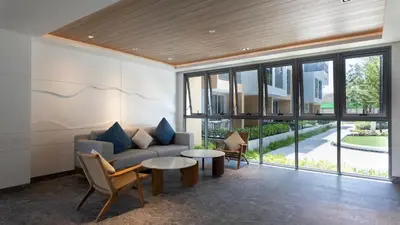 a living room with a couch and a table at Natural Harmony - SkyPark Celeste in Laguna Phuket