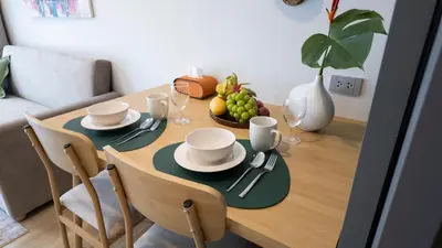 a dining room table with a bowl of fruit on it at Natural Harmony - SkyPark Celeste in Laguna Phuket