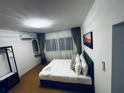 a bedroom with a white bed and a window at Phuket gateway inn in Ban Kathu