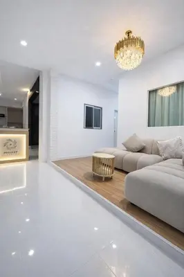 a living room with a couch and a chandelier at Phuket gateway inn in Ban Kathu
