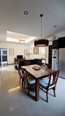 a dining table and chairs in a living room at Two Villas Holiday in Phuket Town