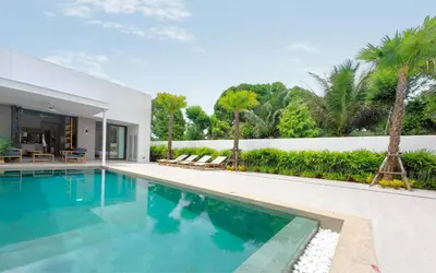 a swimming pool in front of a house at Luxury Private Christina Pool Villa in Ban Phak Chit
