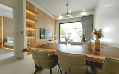 a dining room with a wooden table and chairs at Luxury Private Christina Pool Villa in Ban Phak Chit