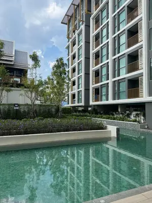 a swimming pool in front of a building at Пляж Бангтао Резиденция Ozon in Laguna Phuket