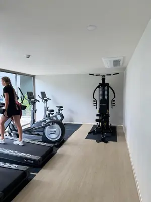 a woman running on a treadmill in a gym at Пляж Бангтао Резиденция Ozon in Laguna Phuket